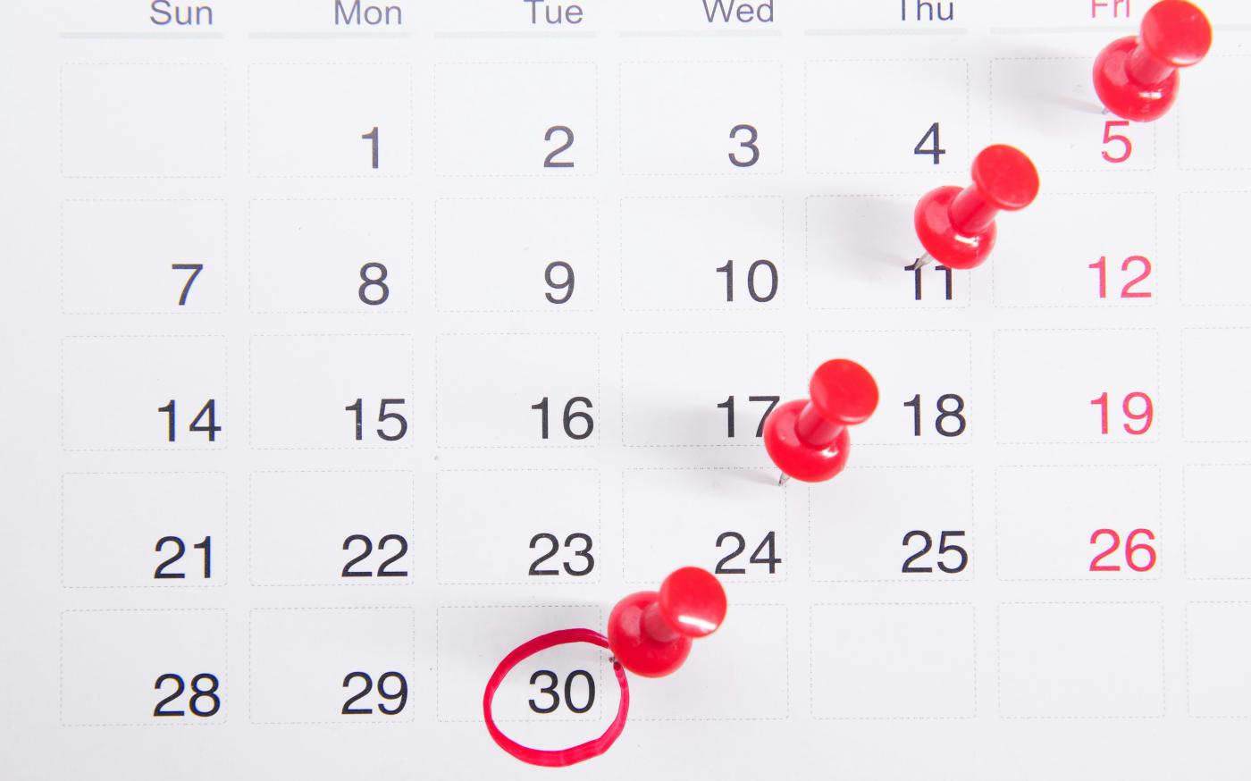 a calendar with red push buttons pinned to it by Towfiqu barbhuiya courtesy of Unsplash.